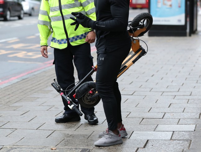 Man holding an e-scooter.